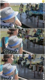 母亲背着孩子看旋转木马