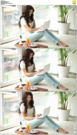 美女坐在窗户边打字上网