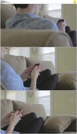 男人躺在沙发上玩手机