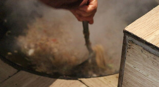 手工烹饪铁勺搅动锅中食材